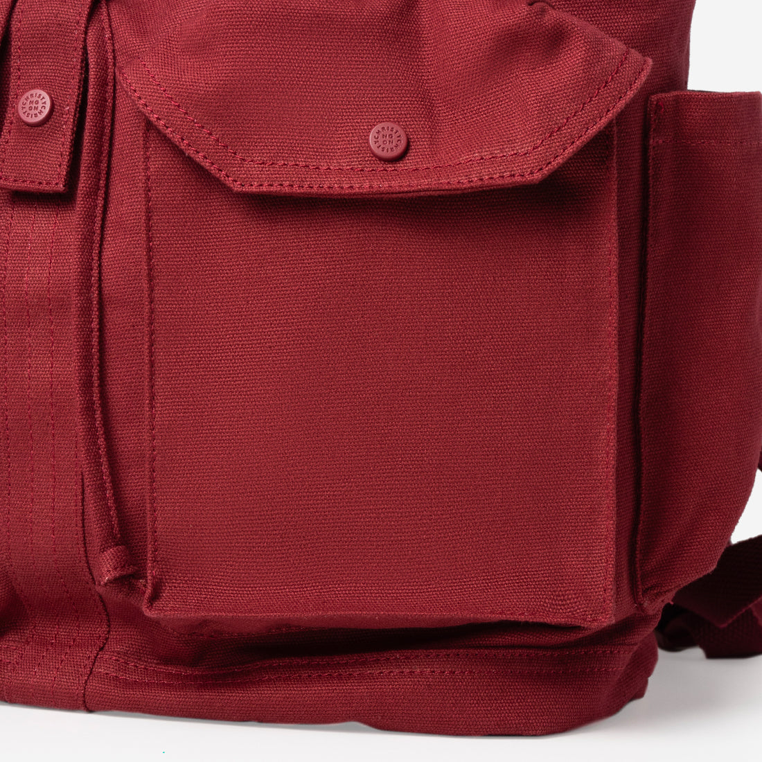 Close-up of the embroidered KUDRAT crest on the red backpack flap